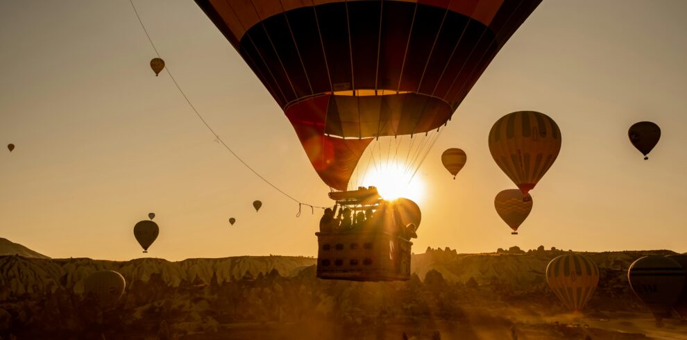 Scenic view of hot air balloons floating over Cappadocia, Turkey at sunrise.
